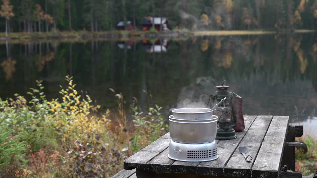 cocinando comida frente a un pequeño lago con