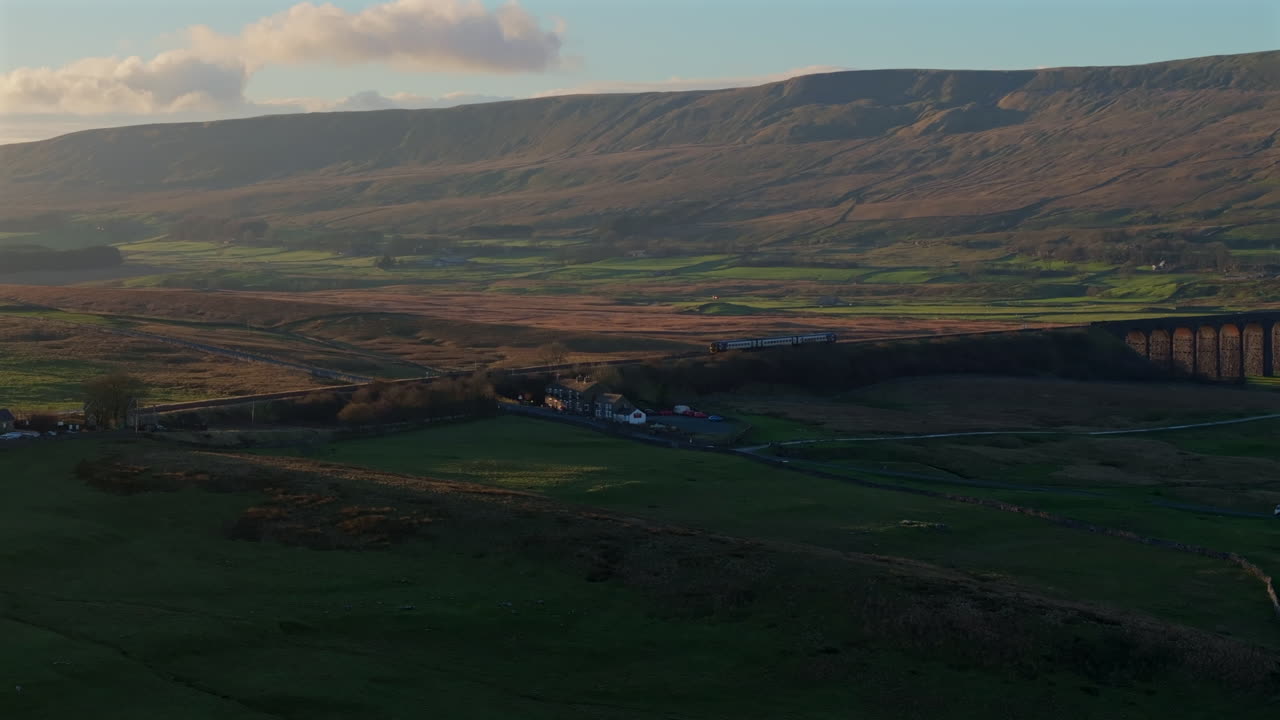 estableciendo una toma de dale con el tren entrando en la estación de ribblehead, reino unido.
