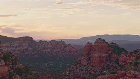 Aerial-pullback-above-stunning-desert-alpenglow-and-blue-hour-on-wide-desert-sandstone-canyon