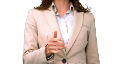 una mujer de negocios bonita lanzando una moneda en la pantalla blanca