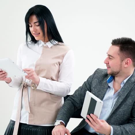 happy man and woman with gadgets isolated on white. handsome man talking to a young pretty woman and smiling together indoors.