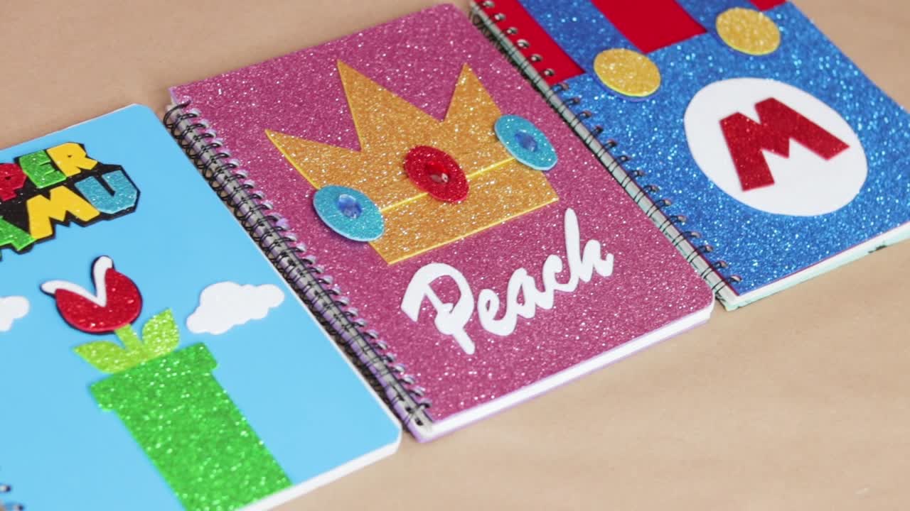 cuadernos infantiles coloridos con tema de videojuegos, estableciendo el tiro