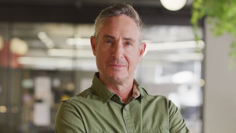 portrait of happy caucasian businessman looking at camera at office