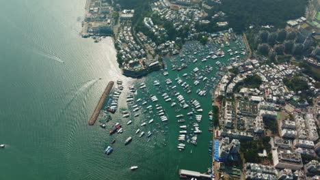 Vista-Superior-Del-Dron-En-órbita-Del-Bullicioso-Puerto-Y-Un-Edificio-Alto-En-Hong-Kong,-China