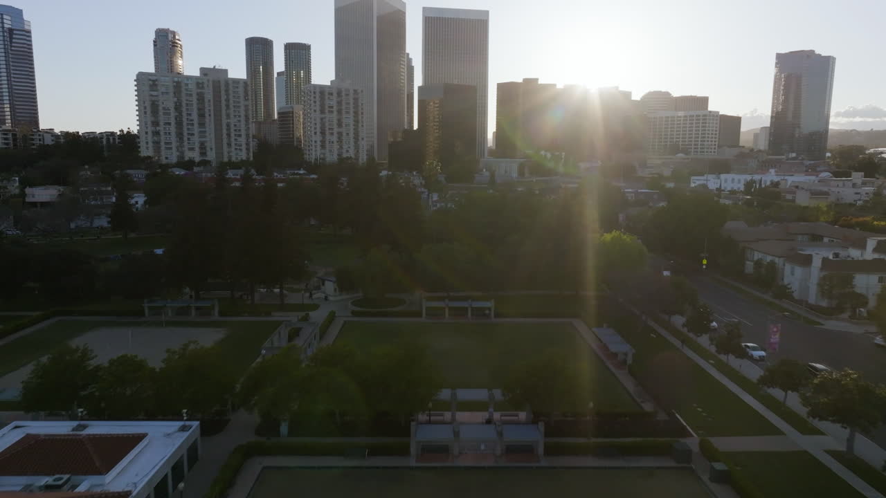 Tomada de drone sobre o Parque Roxbury com a cidade de Culver ao fundo, nascer do sol em Los Angeles, EUA