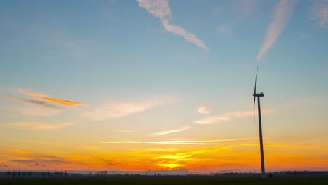 A-windmill-under-the-stunning-transition-of-the-heavens-from-day-to-dark-over-Zlotoryja,-Poland-with-a-shooting-star-traveling-in-the-sky---time-lapse