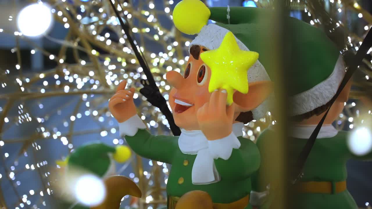 близкий взгляд на счастливых улыбающихся рождественских эльфов модели сидели улыбаясь внутри клетки рождества светящиеся теплые феи огни на переднем плане и фоне