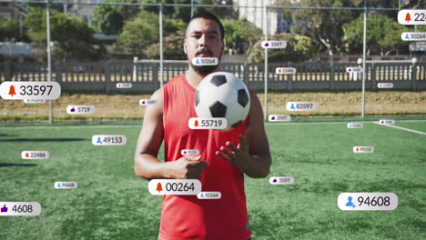 animación de iconos de las redes sociales sobre un jugador de fútbol masculino biracial con una pelota de fútbol en un campo deportivo