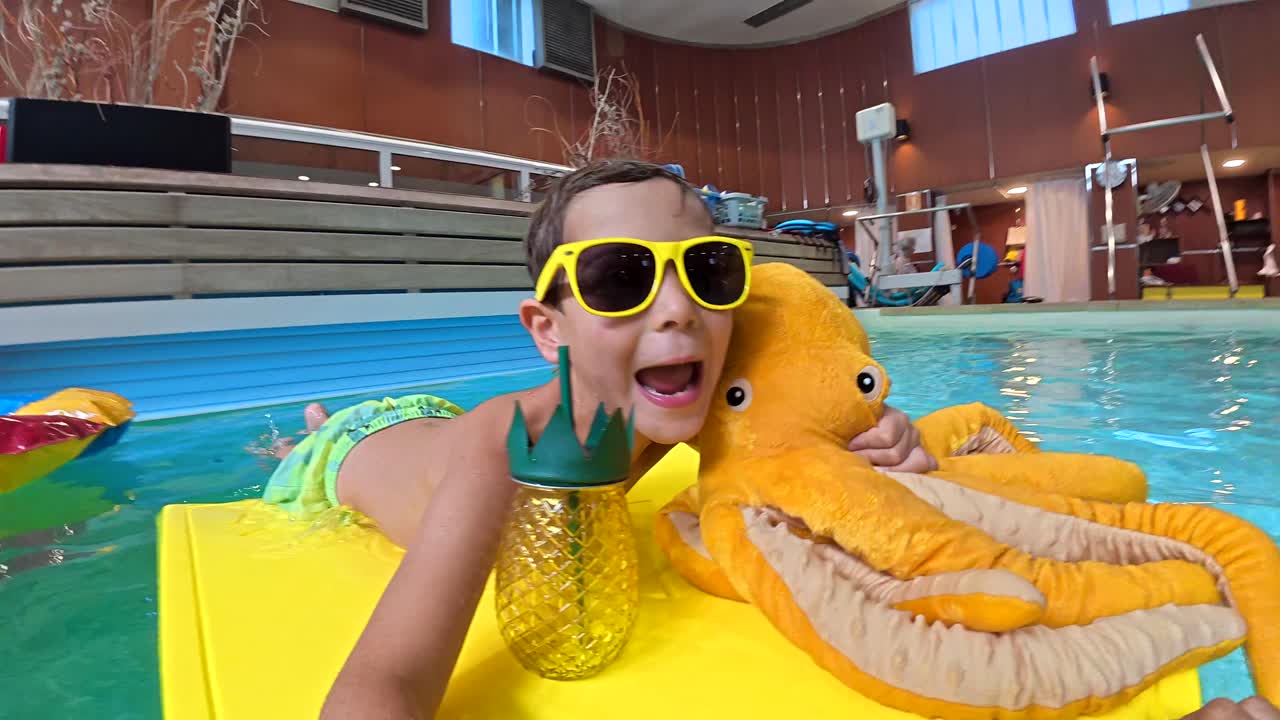 Boy with Octopus Float in Swimming Pool