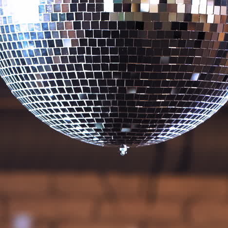 glittering disco ball against black background. dancing or party in the nightclub. round disco ball shimmering at night. close-up.