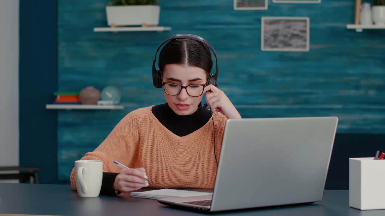 Woman with headphones talking on online video call