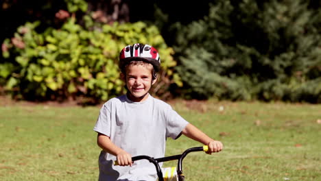 niño orgulloso caminando con su bicicleta