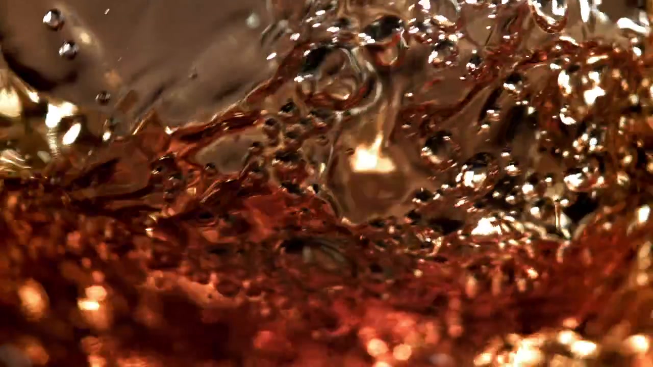 Primo piano dinamico di liquido ambrato dorato che vortica con bolle