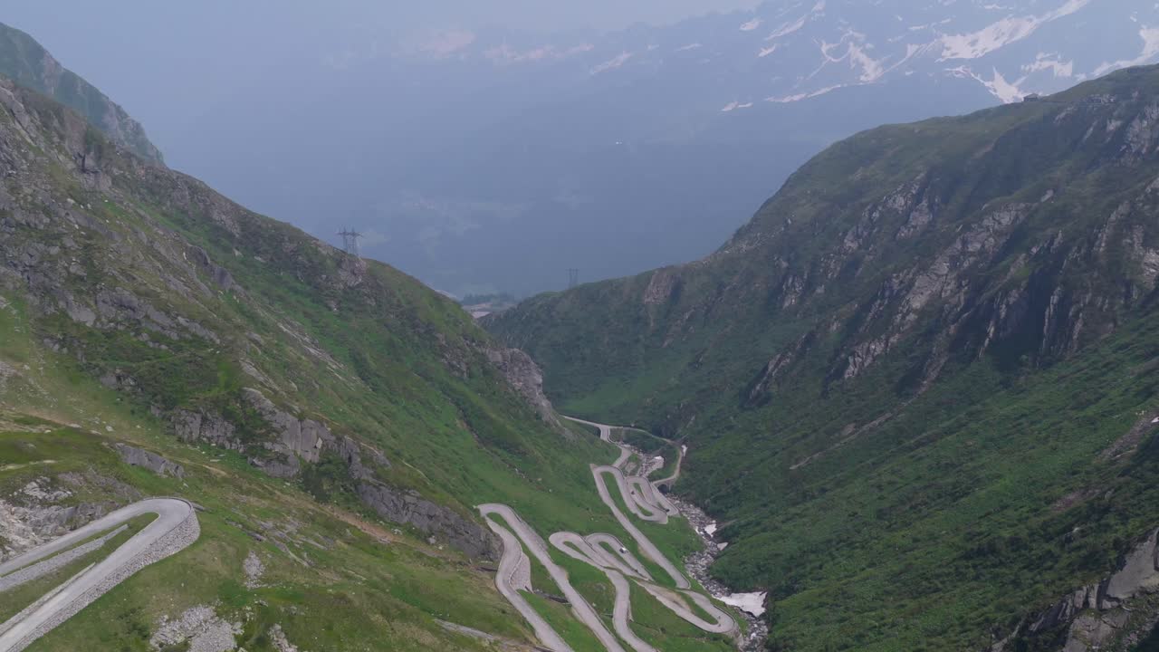 Veduta da drone in campo lungo dell'intera strada serpentina della Tremola che si snoda nella valle.
