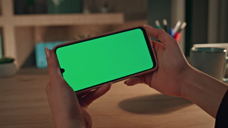 student watching webinar green screen smartphone at home workplace close up.