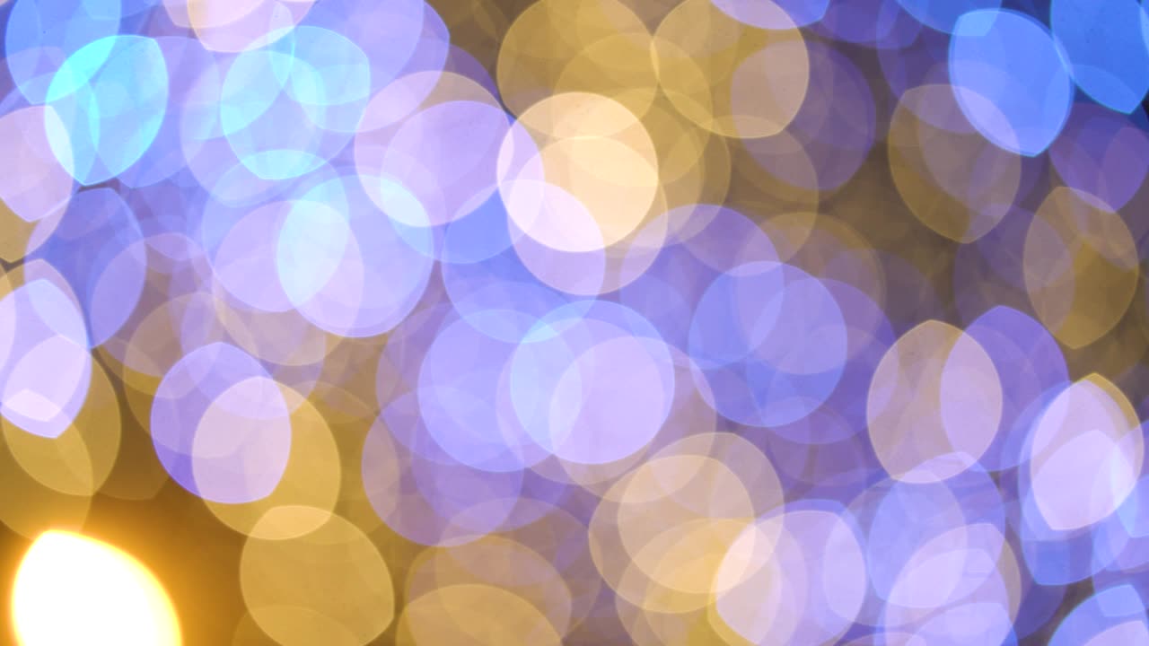Golden and blue bokeh circles of light on dark background