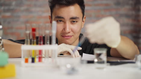 lab assistant works with materials and reagents at table