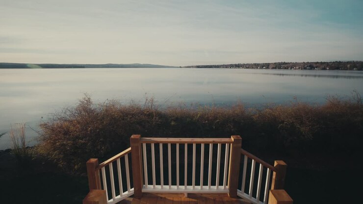 Scale in legno di una casa che si affaccia sul lago calmo al mattino presto