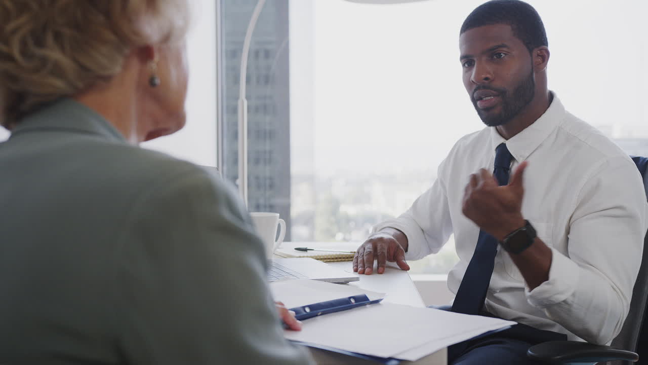 Senior Woman Meeting With Male Financial Advisor In Office