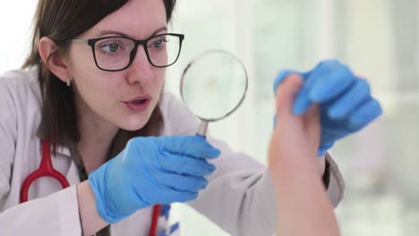 a doctor examines a patient's foot with a magnifying glass