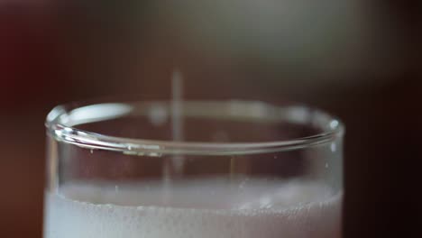 Close-up-shot-of-white-milk-poured-in-a-glass