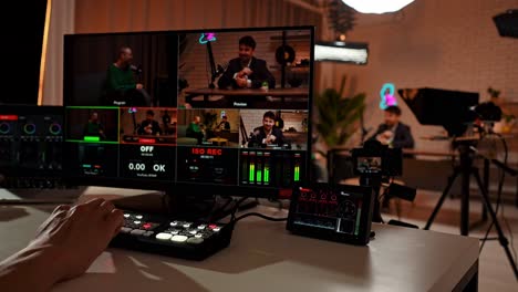 person operating a video production switcher for a live stream or broadcast in a studio