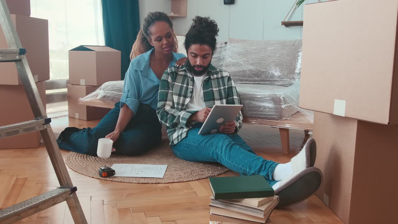 Young multiracial family woman and man arranging apartment after relocation