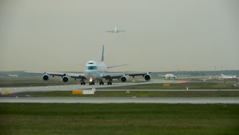 telephoto approaching cargo airplane on runway and starting plane on dusty day