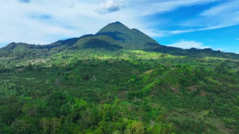 lush nature with street to village in front of matutum mountain in tropical landscape of philippines