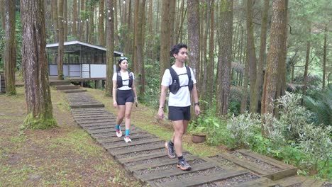 asian couple walking on forest trail path during outdoor adventure in indonesia