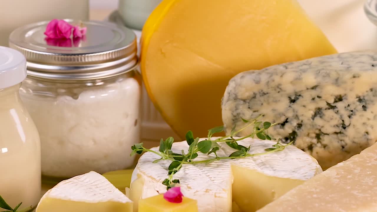 A variety of cheeses and milk bottles arranged on a light background.