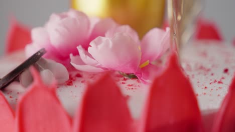 Kuchen-Mit-Rosa-Zuckerguss-Und-Einer-Blume-Im-Hintergrund,-Flugzeugwechsel