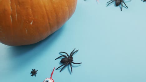 close up view of pumpkin and halloween toys against blue background