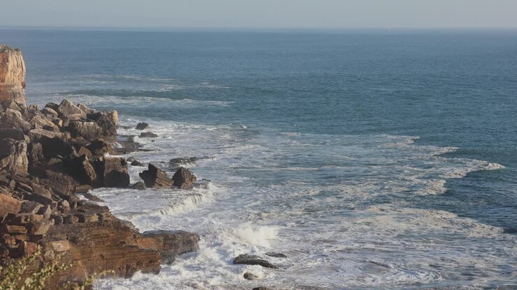 Heuvel die wordt bespoeld door de oceaan in Cascais