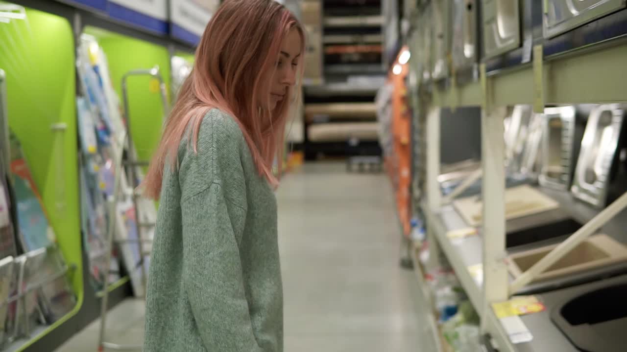 Una donna sceglie un nuovo lavello da cucina in un negozio
