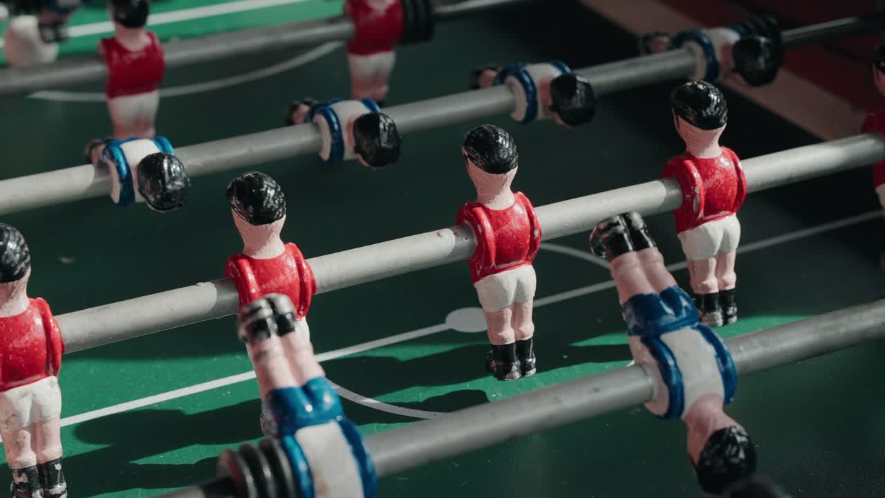 Close up colorful foosball figures on rods in classic tabletop soccer game