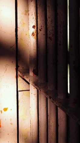 vertical view, alcatraz prison detail, sun shines on metal bars of prison cell, close up