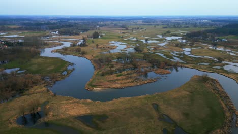 Drohnen-Fliegen-Im-Kreis-Und-Bieten-Eine-Einzigartige-Perspektive-Auf-Die-Atemberaubende-Naturlandschaft-Mit-überfluteten-Feldern-Und-Einem-Sich-Schlängelnden-Fluss