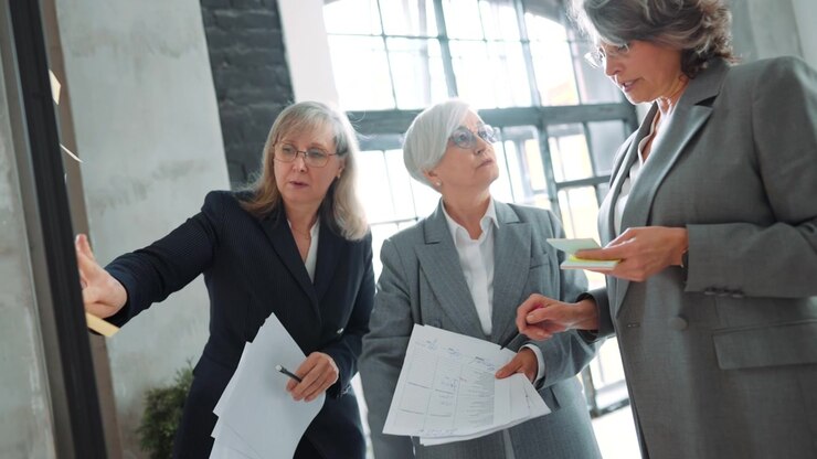 Three Professional Businesswomen Collaborating on a Project in an Office