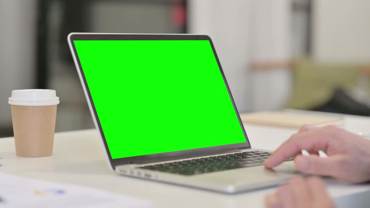 hombre de mediana edad usando una computadora portátil con pantalla chroma