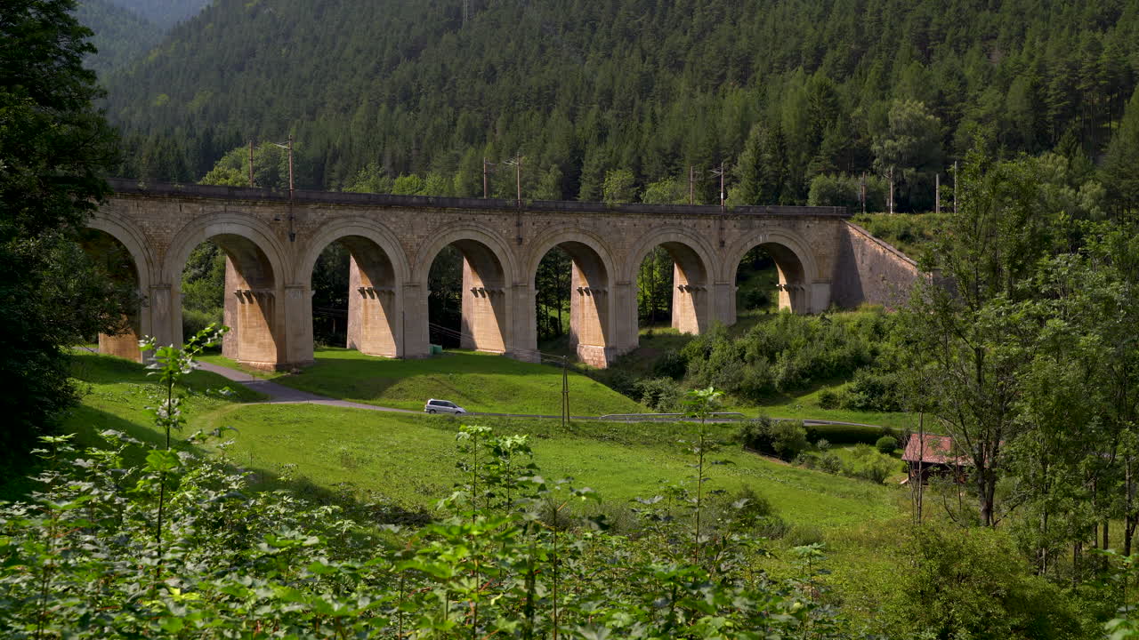 conducción de automóviles a través del hermoso paisaje del viaducto en el ferrocarril semmering en austria