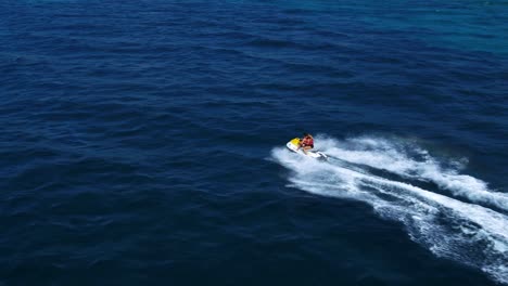 Vista-Aérea-De-La-Pareja-Montando-El-Jetski-En-El-Mar-Por-Drones