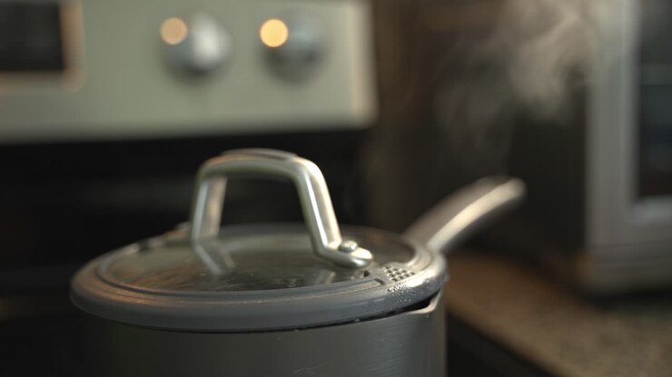 Close up of rice being cooked steam coming out the side of the pot special ingredients to cook a meal two cans of beans rice plantain avocado red onion and cilantro