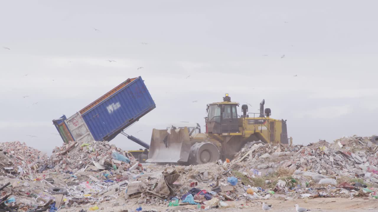 vehículos que limpian la basura apilada en un vertedero lleno de basura