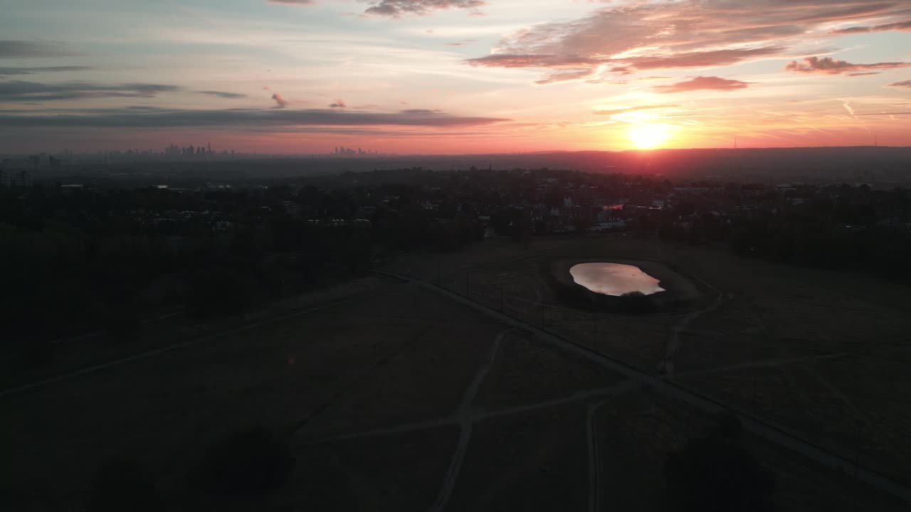 런던 스카이라인을 배경으로 일출 시 윔블던 위로 앞으로 이동하는 공중 샷