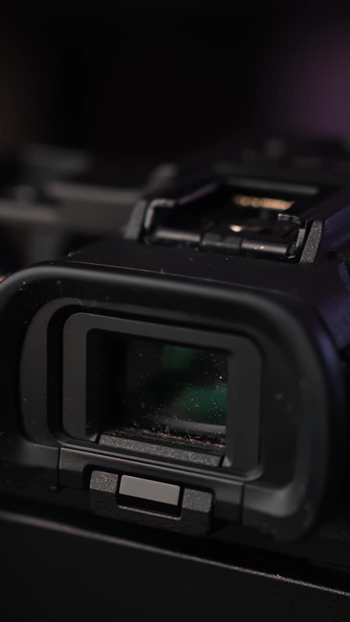 Close-up of mirrorless camera electronic viewfinder eyepiece with dust particles, cinematic macro shot of photography gear details. Vertical shot