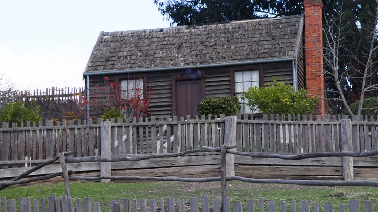 Un cottage rustico con una recinzione in legno