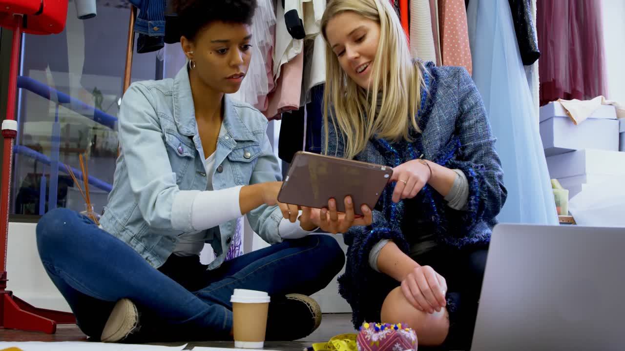 diseñadores de moda discutiendo sobre una tableta digital 4k