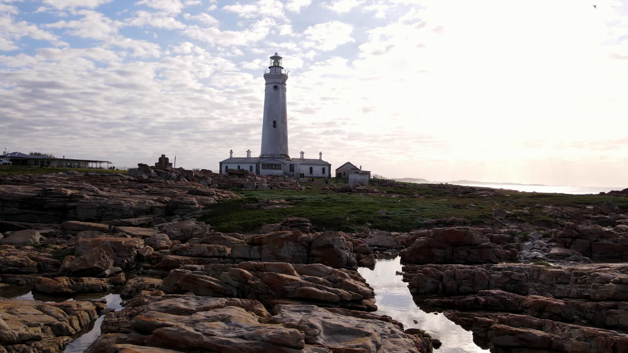 Low aerial shot over jagged coastline of Seal Point lighthouse, Cape St Francis