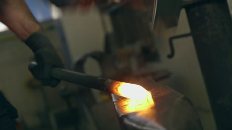 blacksmith hitting glowing metal with hammer